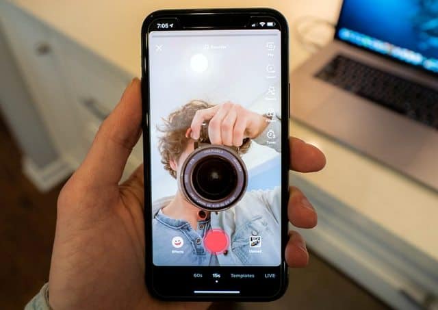 Person pointing camera objective into a phone selfie camera set on recording.